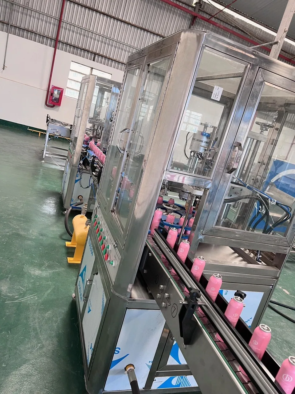 Pink aerosol cans on a conveyor, view 04